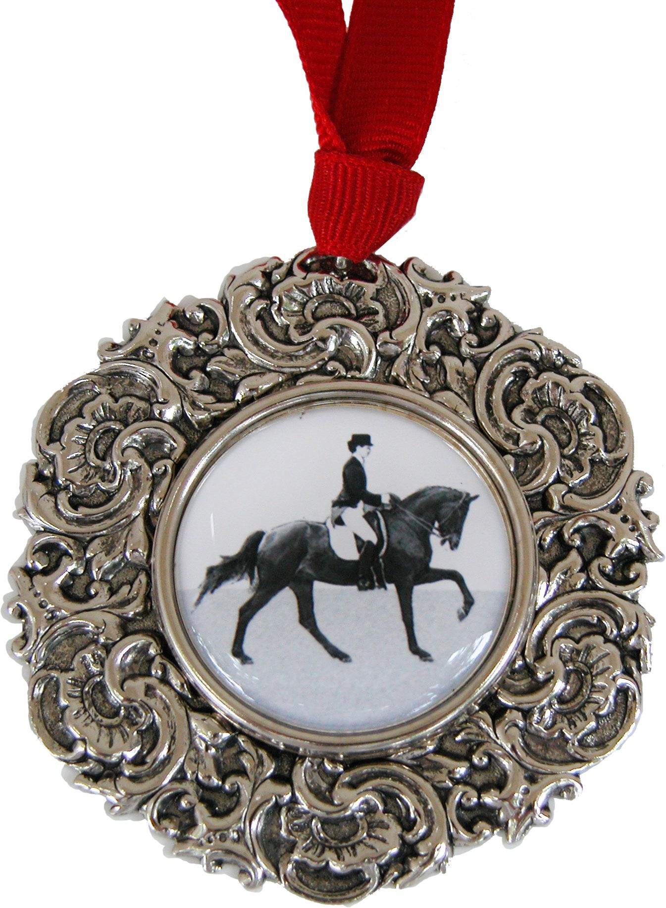 Decorative silver ornament with a dressage horse and rider design on a white background, hung with a red grosgrain ribbon