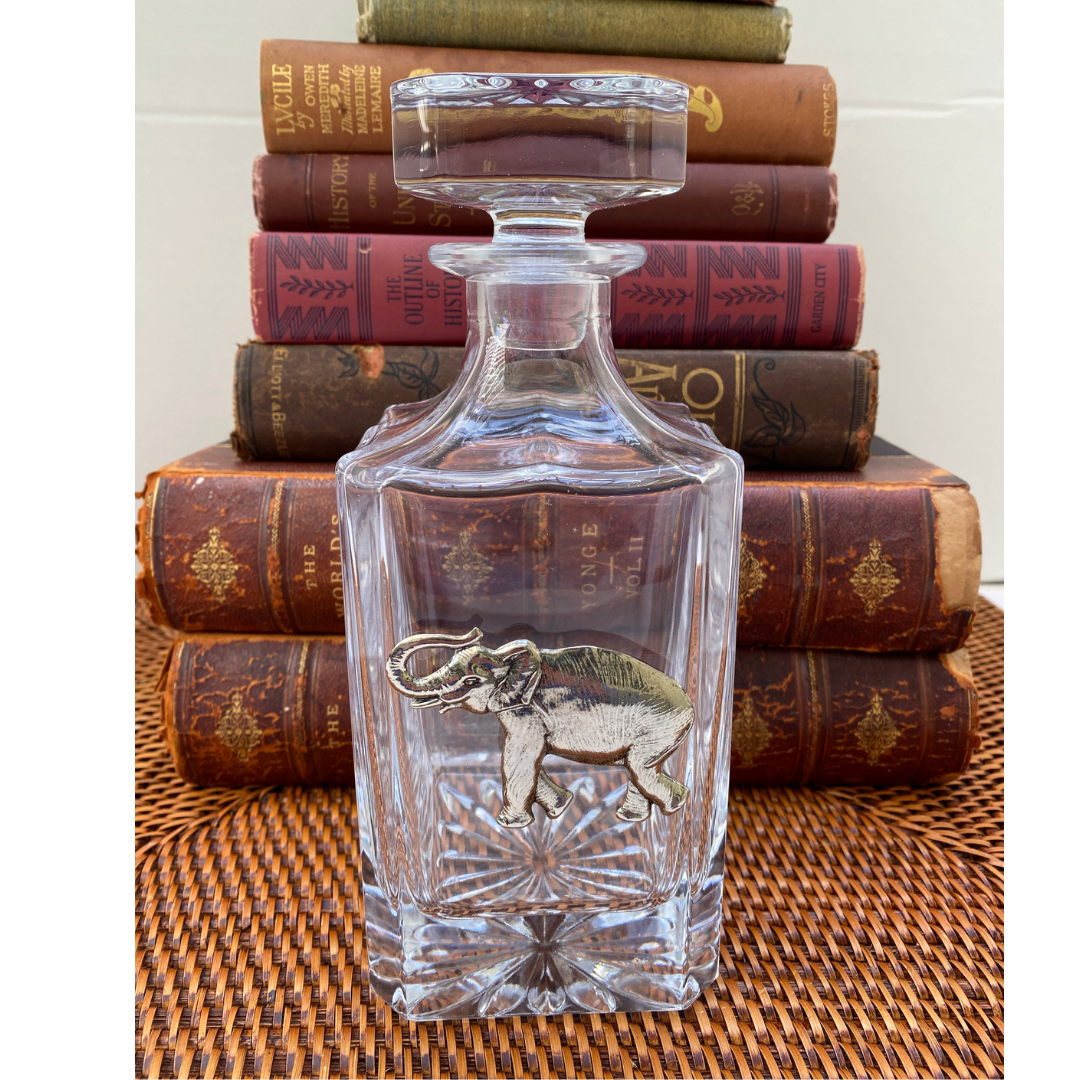 A clear glass decanter with a large silver elephant medallion embellishment. Gift for Alabama fans