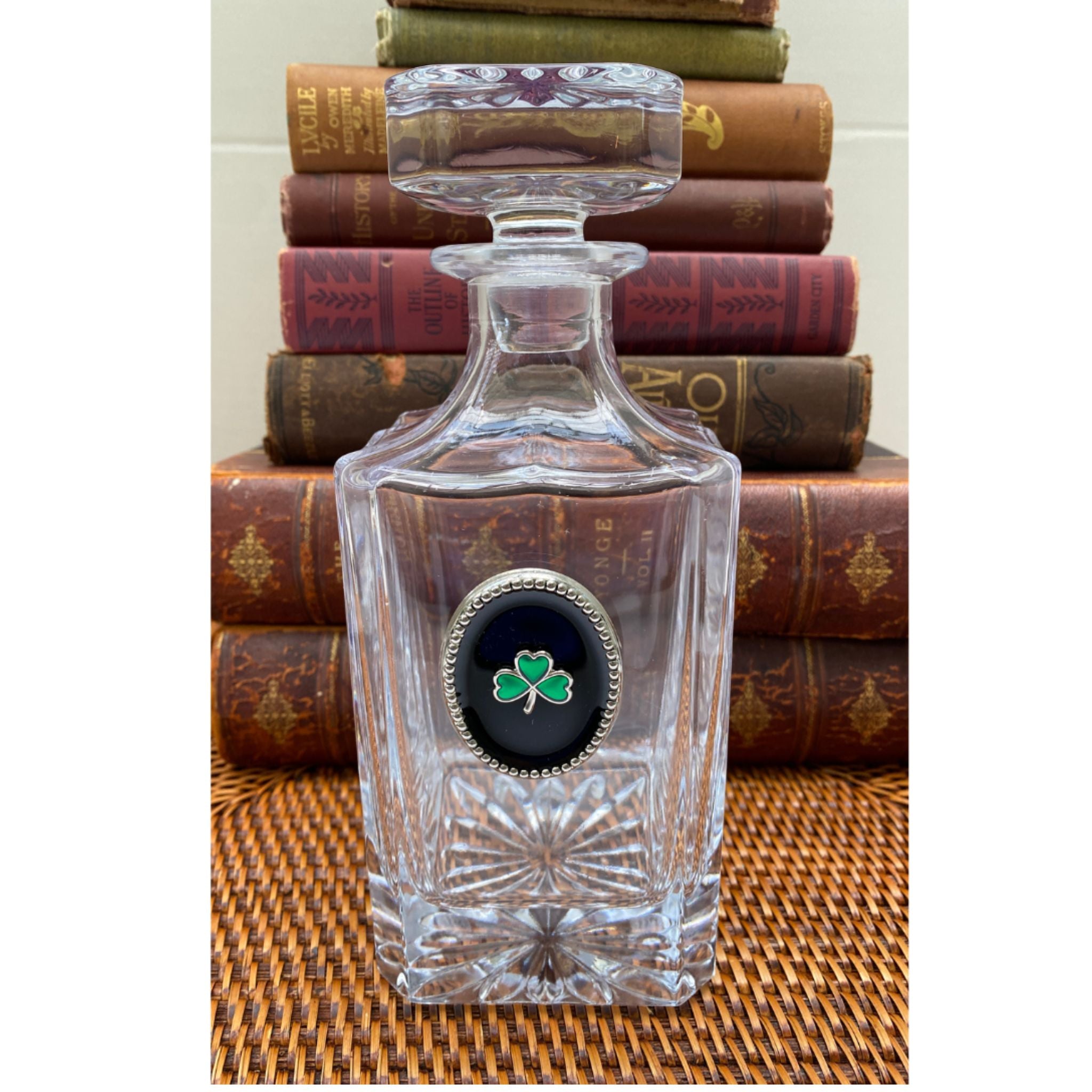 A clear glass decanter with a black enamel center featuring a green shamrock. Great gift for lover of all things Irish.