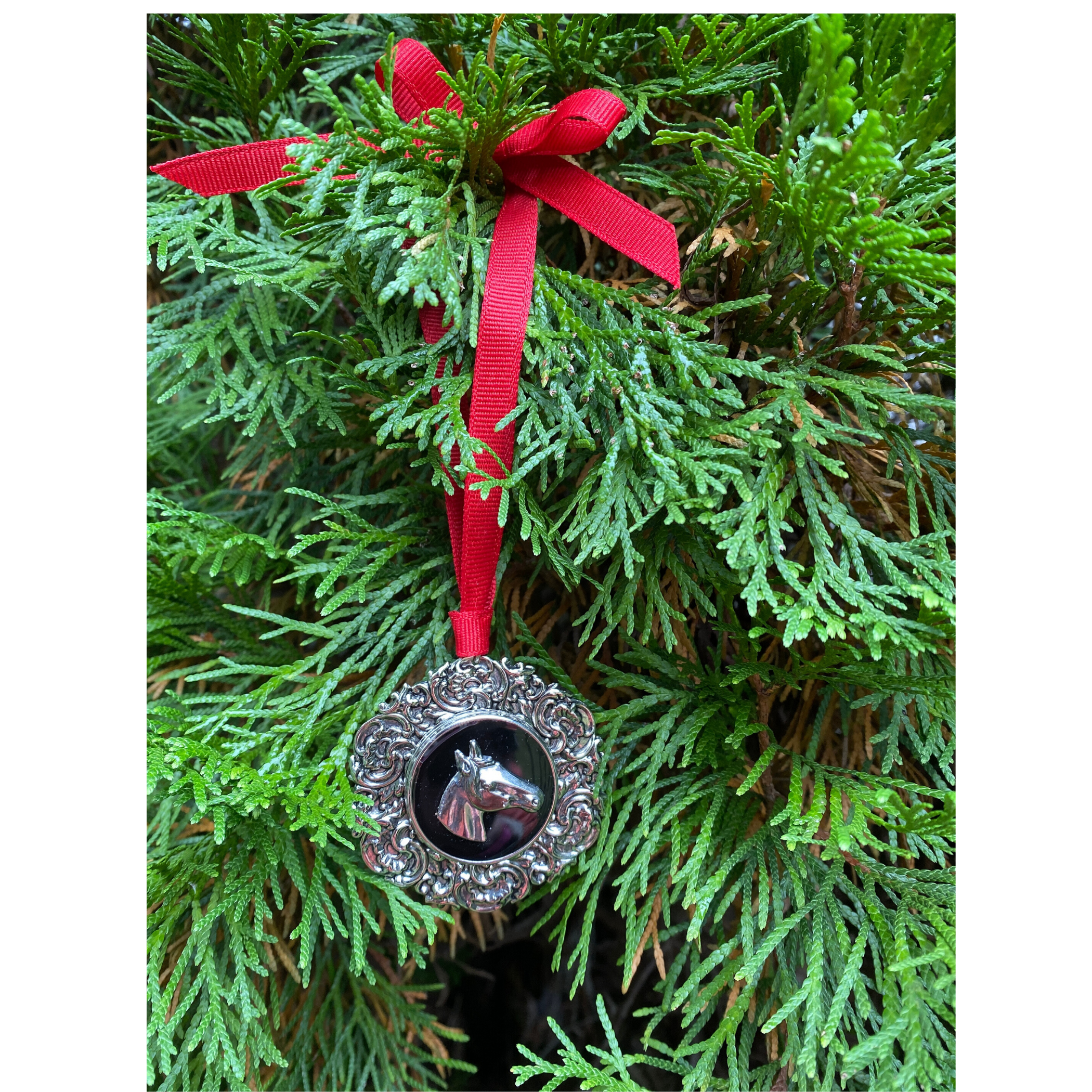 Christmas ornament for horse lover with silver horse head hanging on a Christmas tree with a red grosgrain ribbon