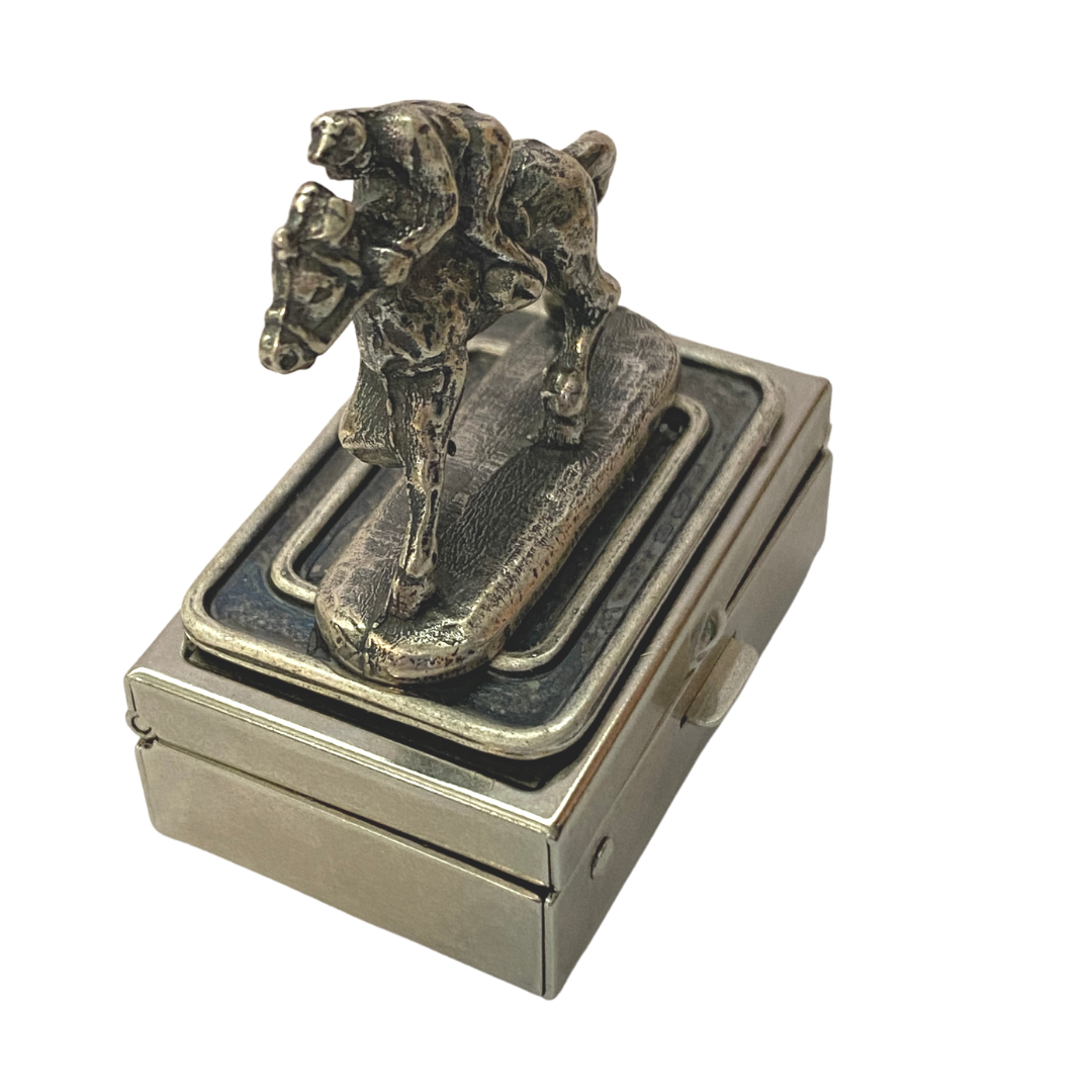 A silver box with a horserace theme featuring a racehorse and jockey design.