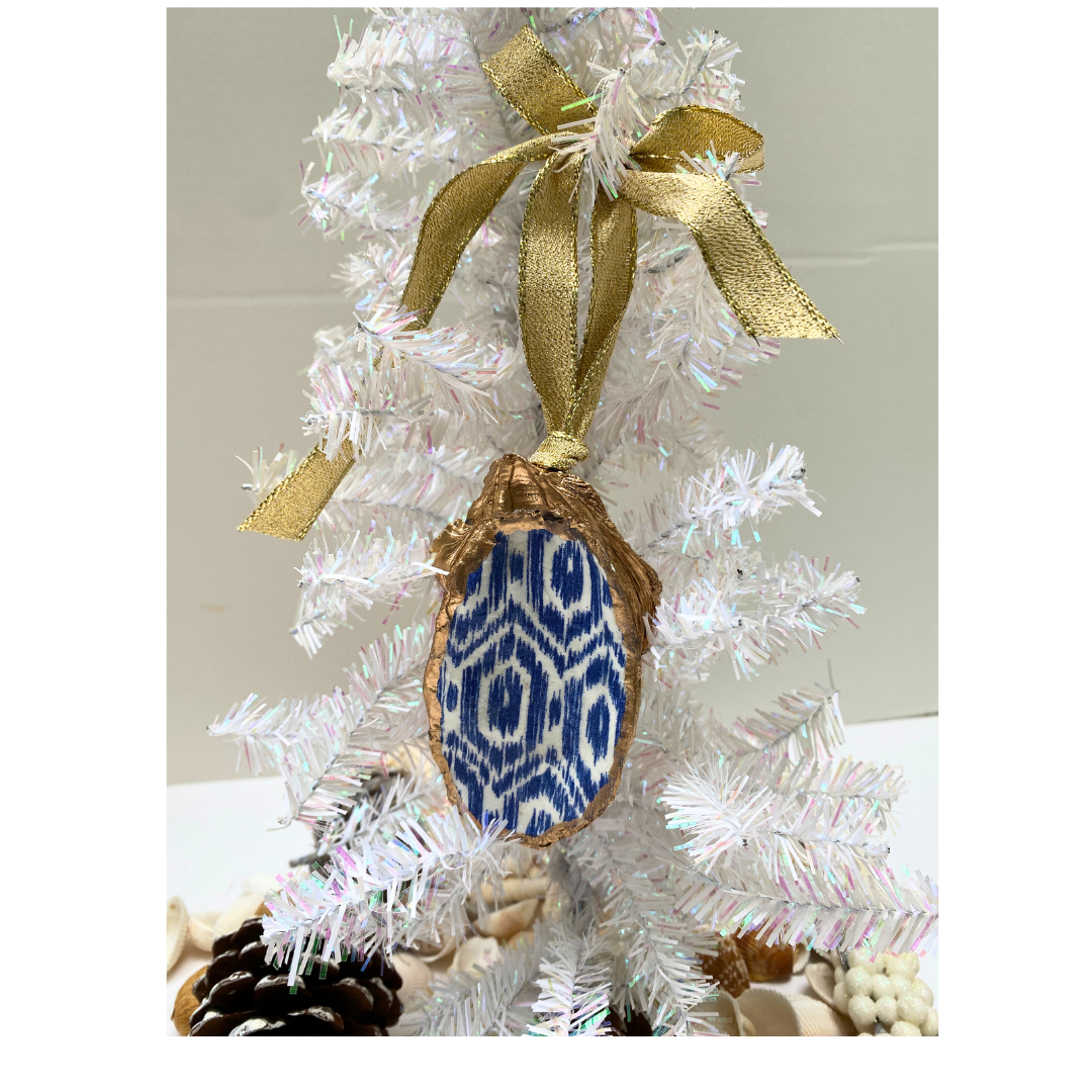 Blue Ikat Beach Christmas Ornament hung with a gold ribbon