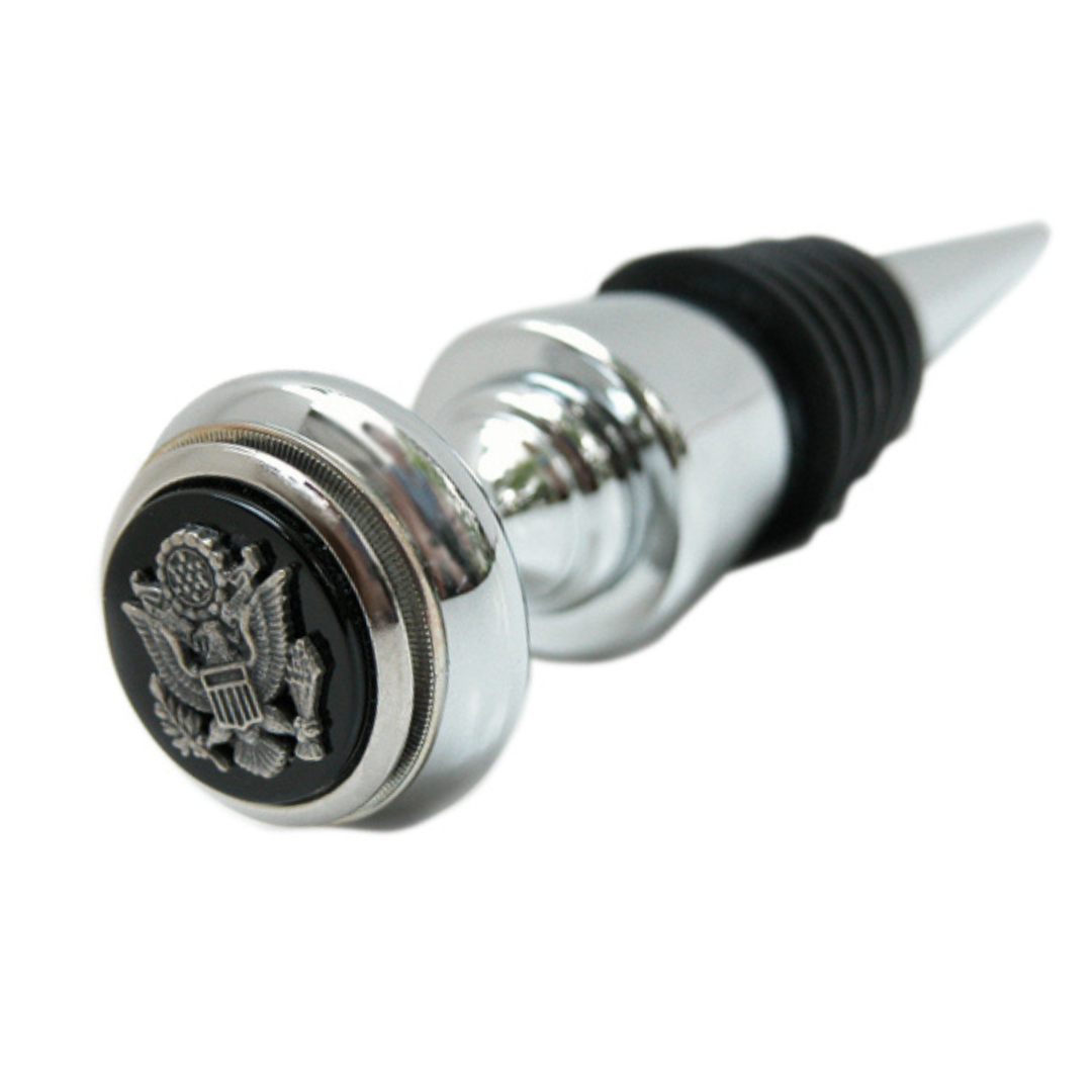 A silver wine bottle stopper with black enamel detailing featuring the Great Seal of the USA.