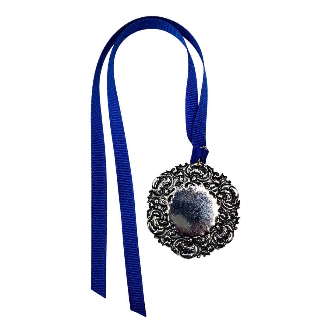 The Custom Christmas Ornament in the Classic Legacy collection is designed with a vintage inspired silver medallion.  In the center is the art of logo.  This is a personalized gift for corporations, hotels, and museums.  Shown is the base of the ornament .