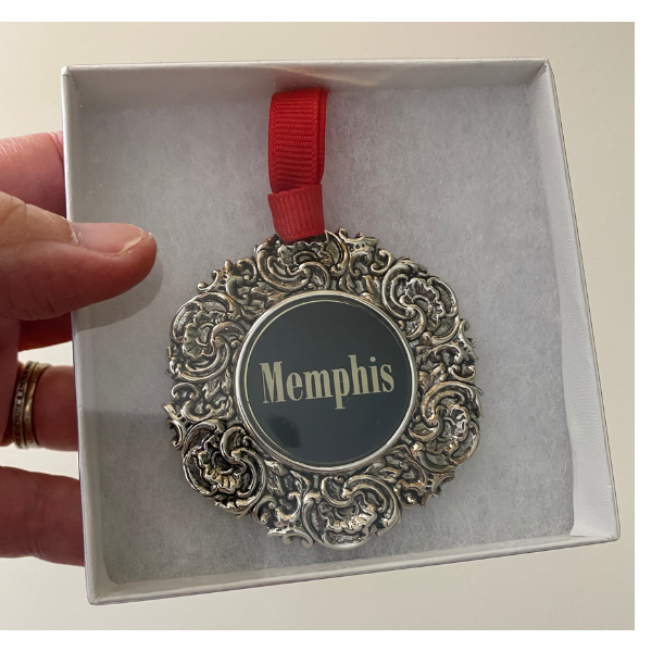 The Custom Christmas Ornament in the Classic Legacy collection is designed with a vintage inspired silver medallion.  In the center is the art of logo.  This is a personalized gift for corporations, hotels, and museums.  Shown is how the ornament is gift boxed.