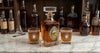The horserace decanter set  includes a large decanter embellished with a silver medallion and a large art image of a vintage racehorse.  The Bourbon glasses are also embellished with silver medallions.