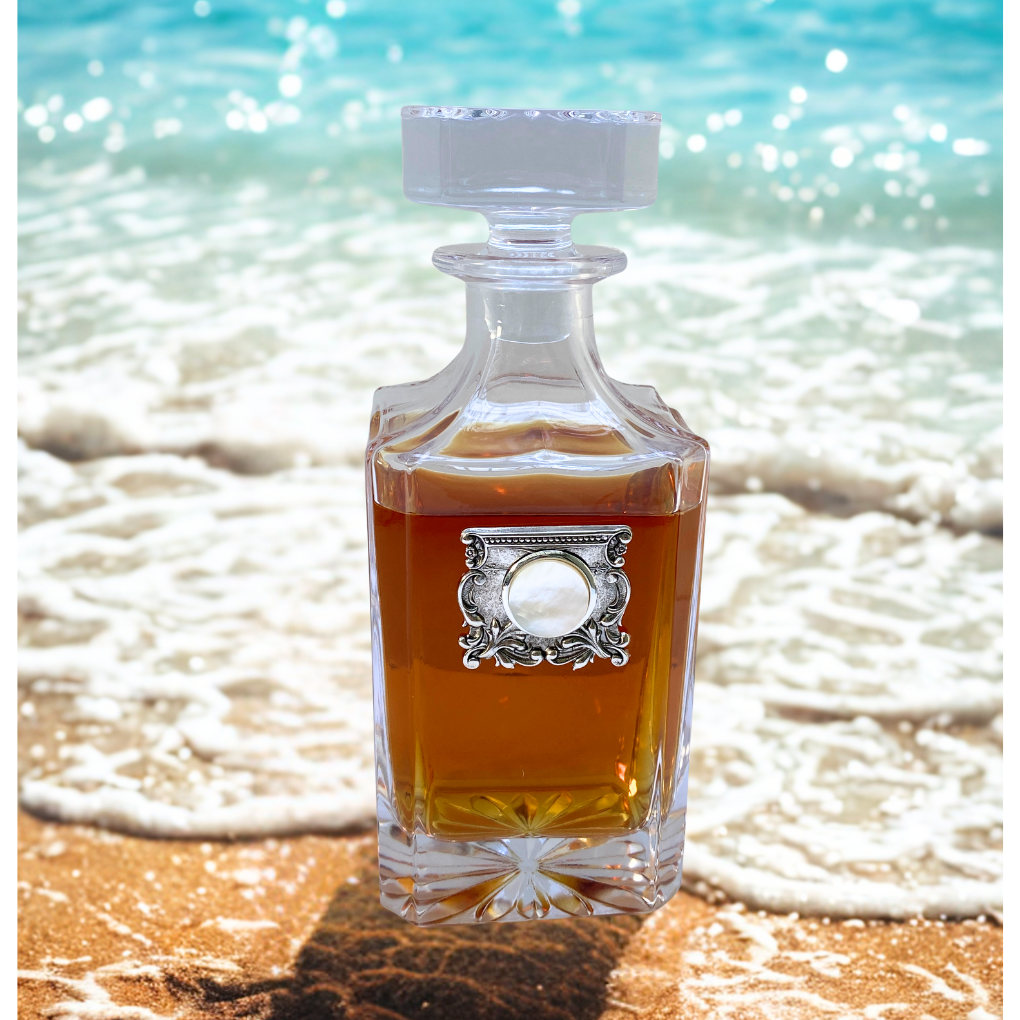 Decanter with silver medallion and pearl setting shown on beach