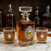 The horserace decanter set  includes a large decanter embellished with a silver medallion and a large art image of a vintage racehorse.  The Bourbon glasses are also embellished with silver medallions.