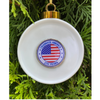 White ornament with American flag design and 'Celebrate America 250 Years' text, hanging on a tree.
