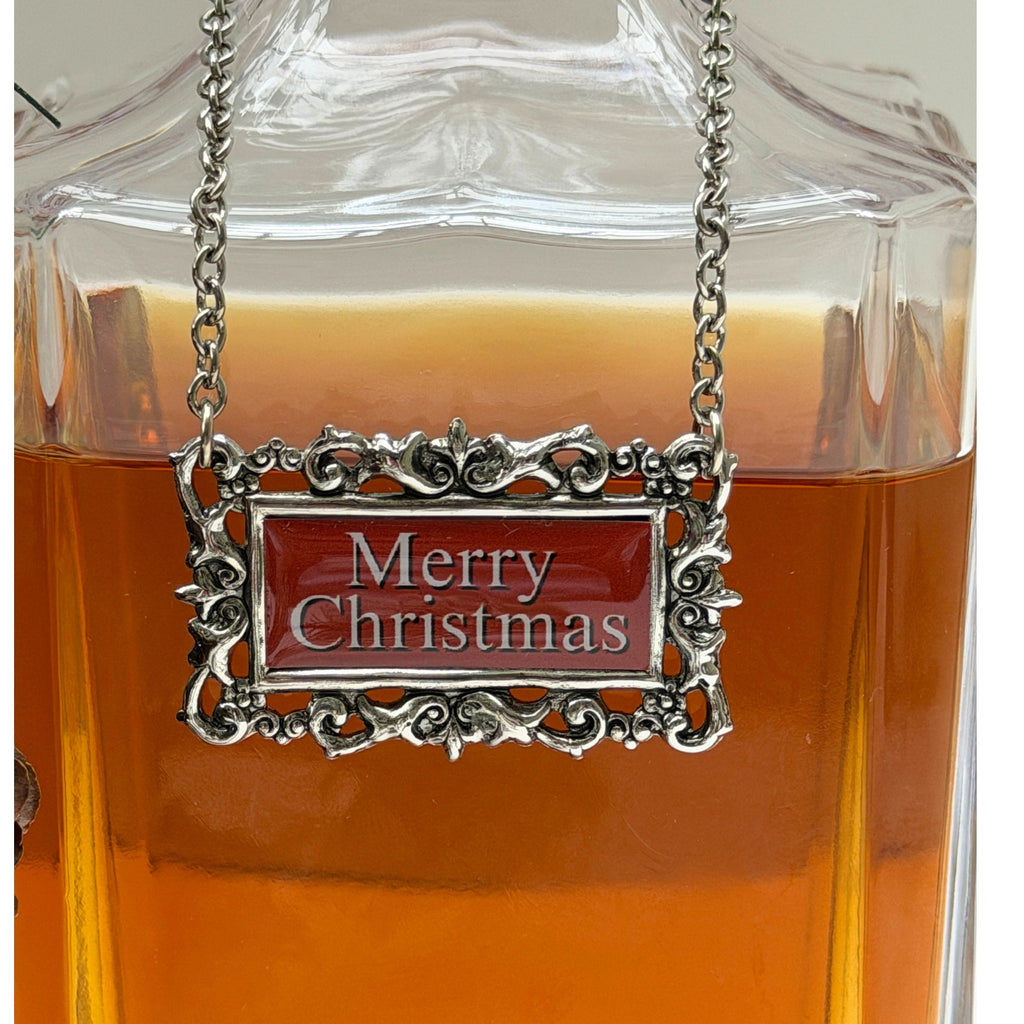 Silver 'Merry Christmas' pendant on a glass container with amber liquid