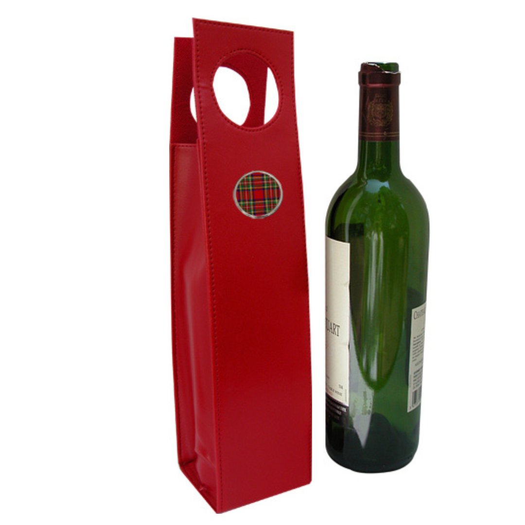 A red faux leather beverage carrier with a large red plaid medallion, designed to hold a wine bottle, displayed next to the bottle.