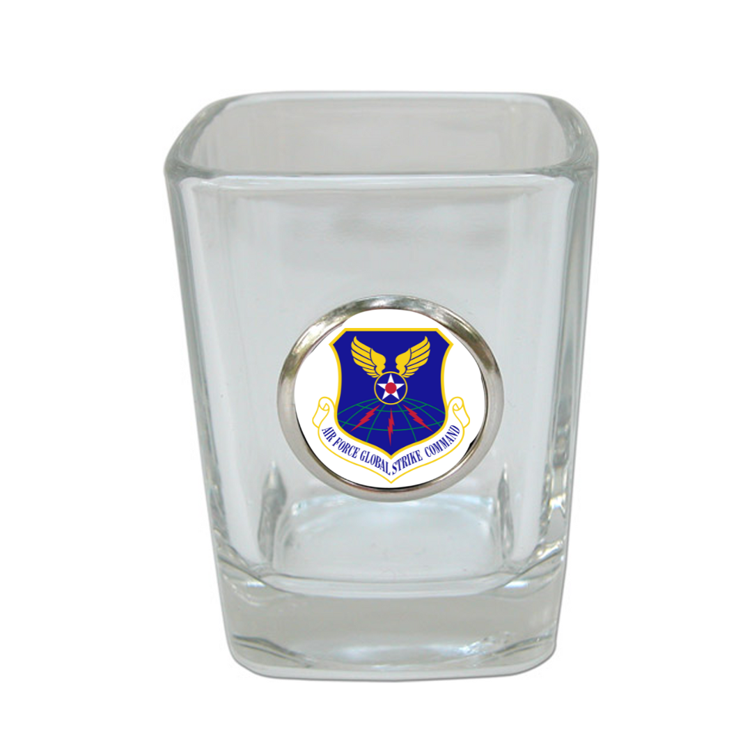 A clear shot glass with a silver medallion and a custom Airforce logo embossed in the center.