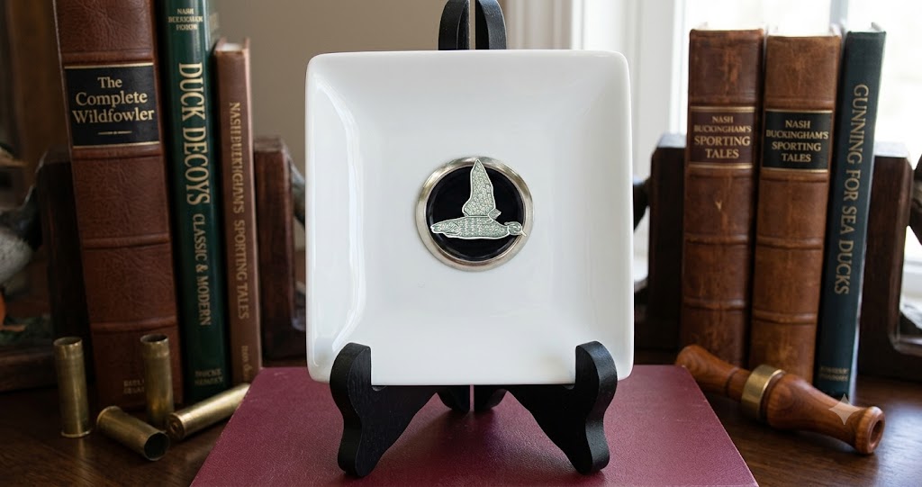 Our duck hunter theme trinket tray is white porcelain and features a large silver medallion with black enamel and a silver duck.   This is a great gift for a duck hunter and duck lover. 