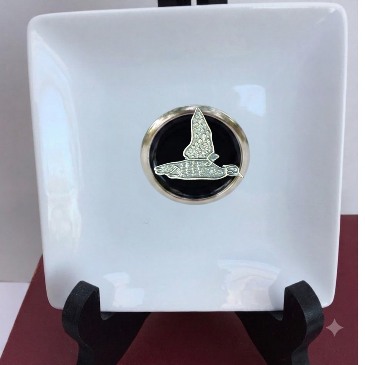 Our duck hunter theme trinket tray is white porcelain and features a large silver medallion with black enamel and a silver duck.   This is a great gift for a duck hunter and duck lover. 