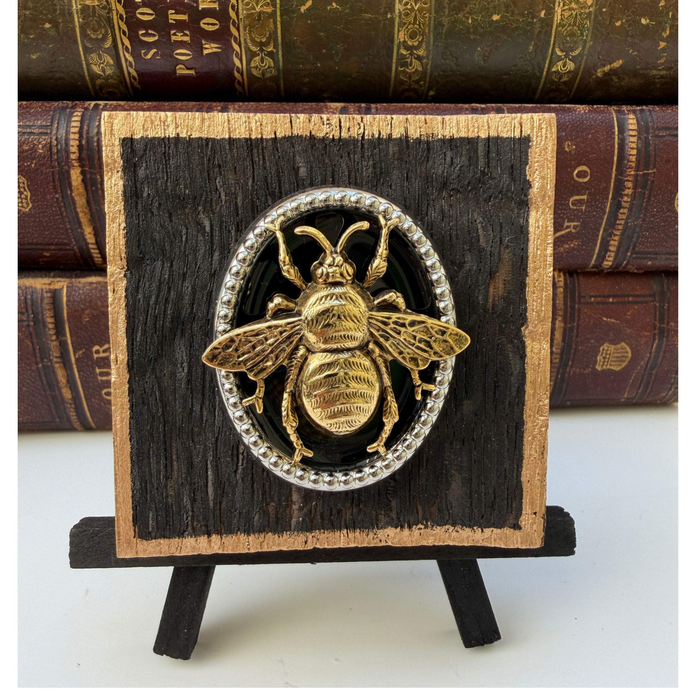 Wooden art with gold bee on a silver medallion with black enamel