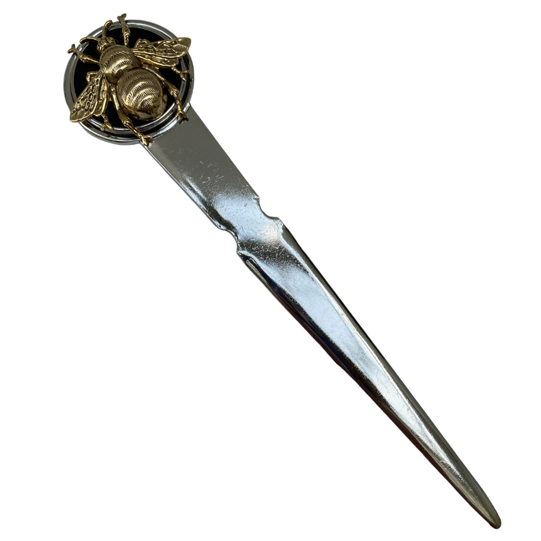 A silver letter opener featuring a large circular black enamel medallion with a gold bee design on top. Gift for bee lover
