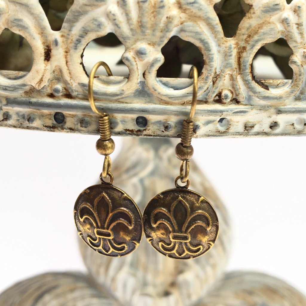 These brass ox earrings are a wonderful gift for Fleur de Lis lovers. The round brass ox convex medallions are embossed with the fleur de lis design.  The medallions are attached to oxidized brass French wire earrings. Each pair of earrings comes on a display/gift card. The dimensions are 1.25" round.