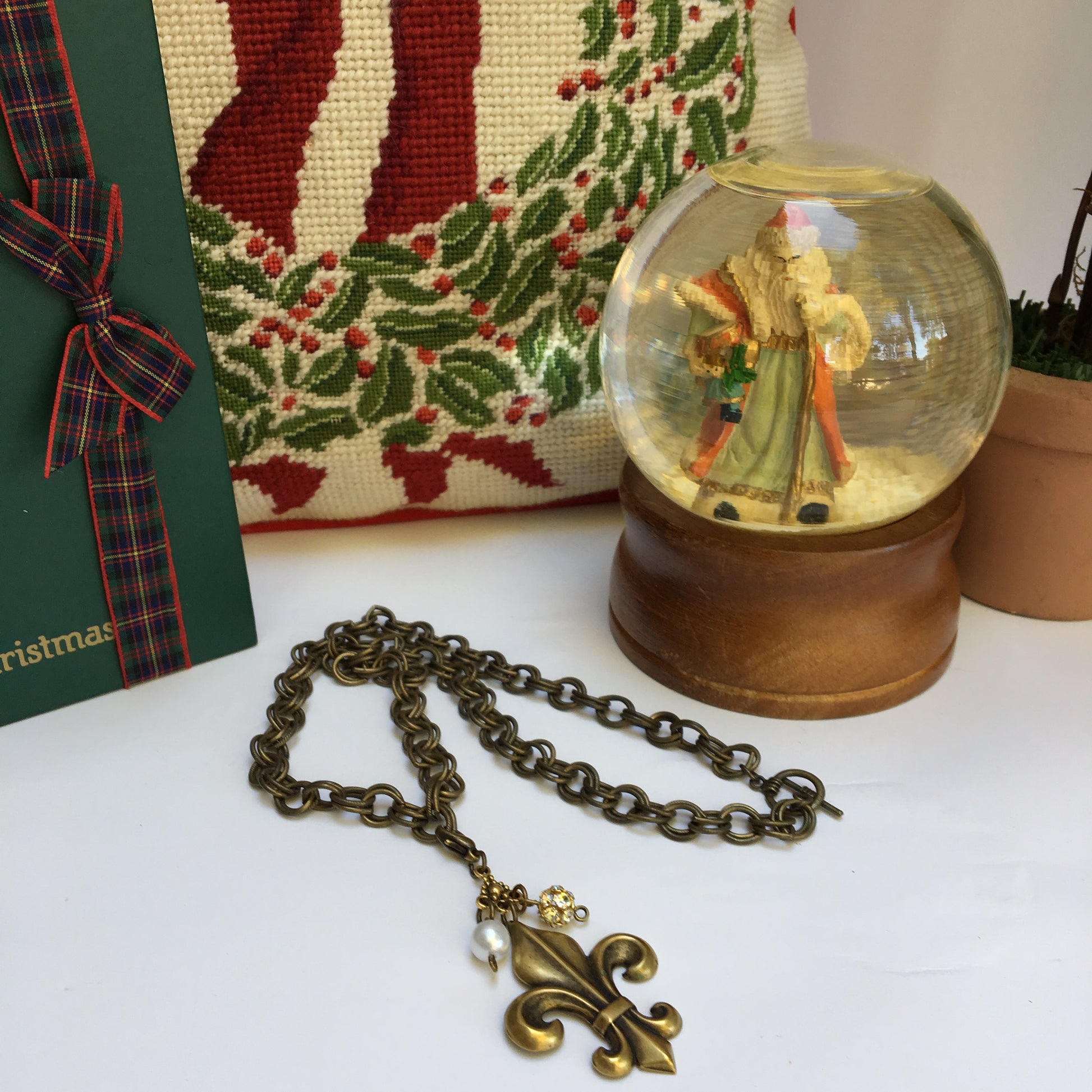 Our double link antique brass chain holds a stunning  antique gold fleur de lis embellished with crystal beads.   The necklace is 18" long and the closure is a toggle clasp.   This comes in a suede pouch for easy gift giving.  Sure to please fleur de lis lovers!   
