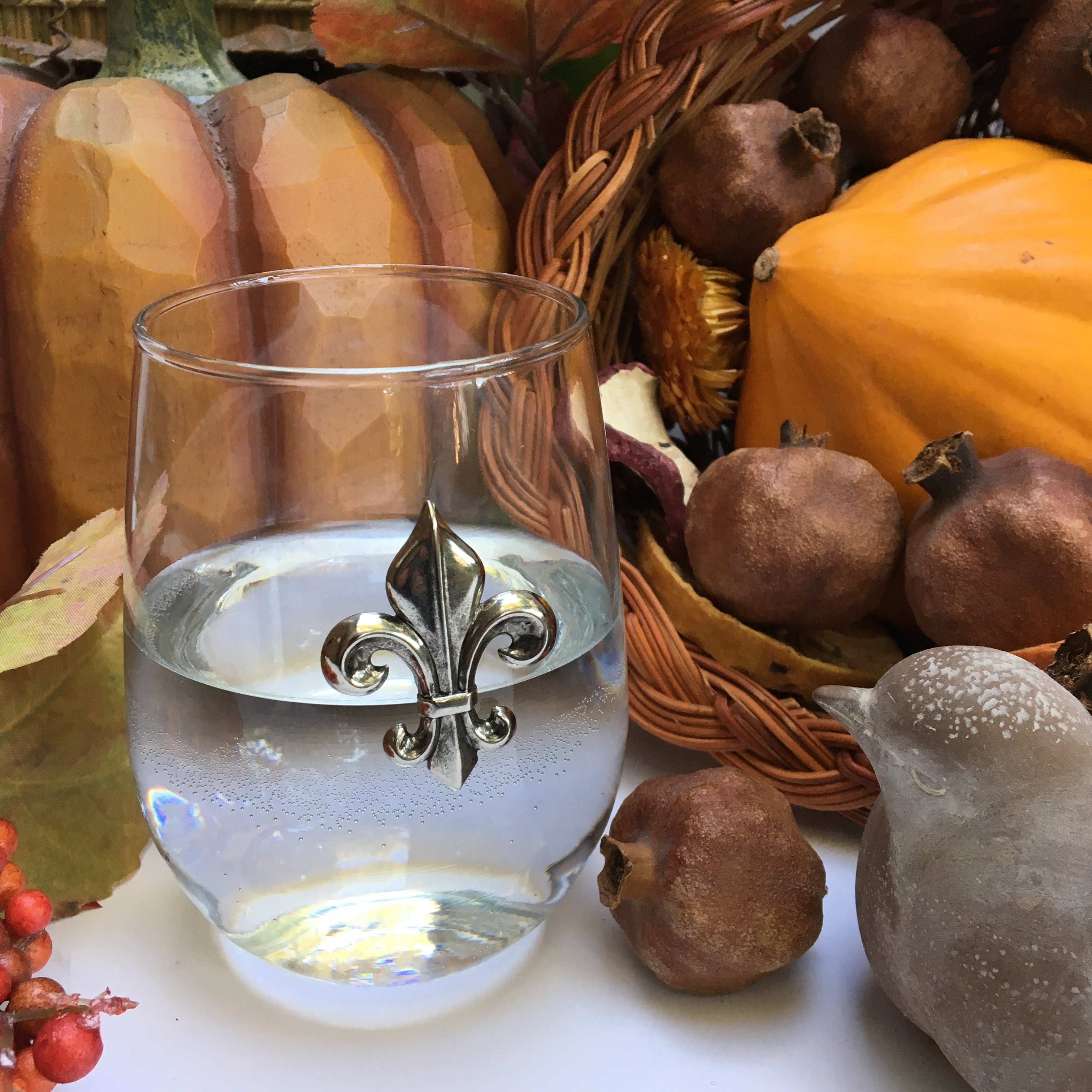 Stemless wine glass with Silver Fleur de Lis medallion. The Classic Legacy stemless wine glass holds 17 ounces of wine. Dimensions are 4.75” x 2.75”. Great table top gift for fleur de lis lovers!  