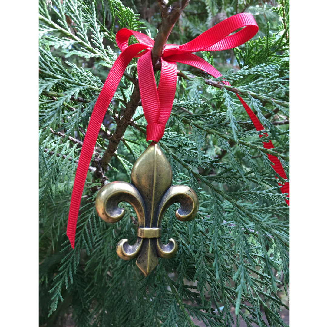 Our fleur de lis Christmas ornament is solid brass and plated in gold, silver, or antique brass.  It is 2.75" long with 24" or red grosgrain ribbon to hang on your tree.   Celebrate all things fleur de lis at Christmas!  