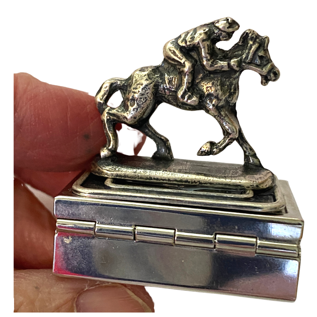 holding the small silver box with racehorse and jockey